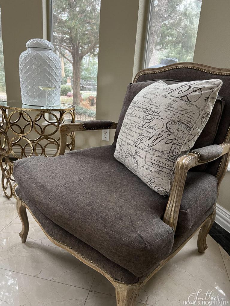 French script pillow in French bergere chair