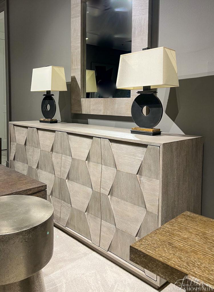 Neutral gray wood cabinet with geometric interest and black modern lamps