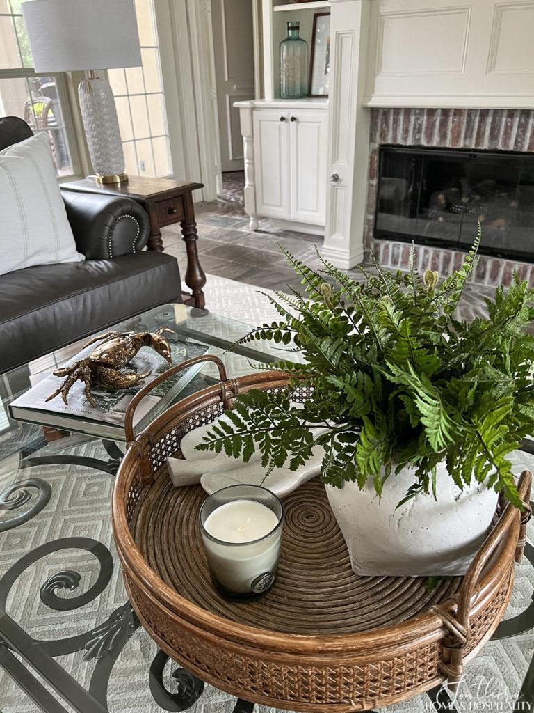 summer coffee table styling with fern , candle, rattan tray