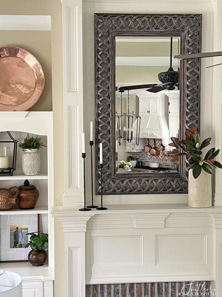 fireplace mantel with magnolia and iron candlesticks, mirror