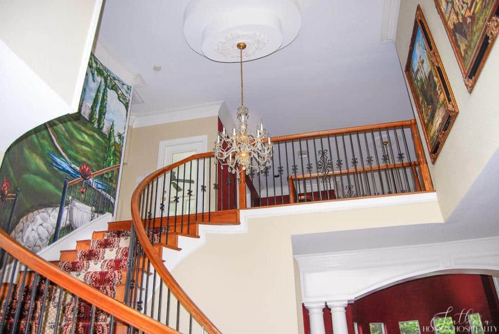wall mural over staircase and 90's crystal and brass chandelier