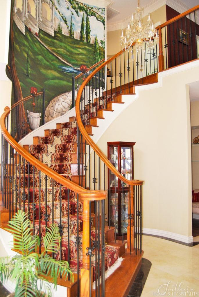 90's staircase before with wall mural and oriental carpet runner, brass stair rods