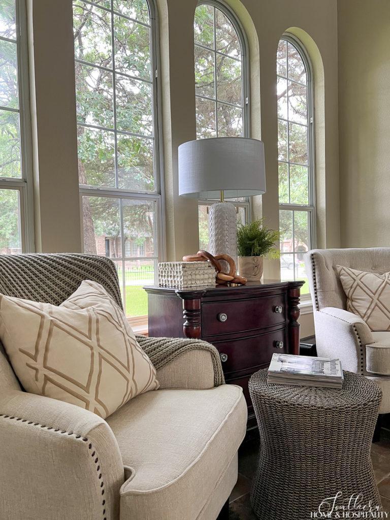 accent chairs flanking chest and wicker ottoman