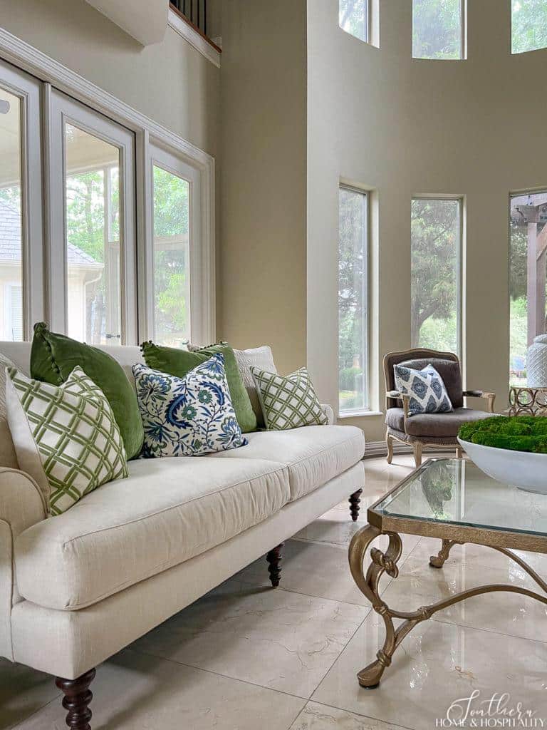 traditional living room with white linen sofa and green and blue throw pillows