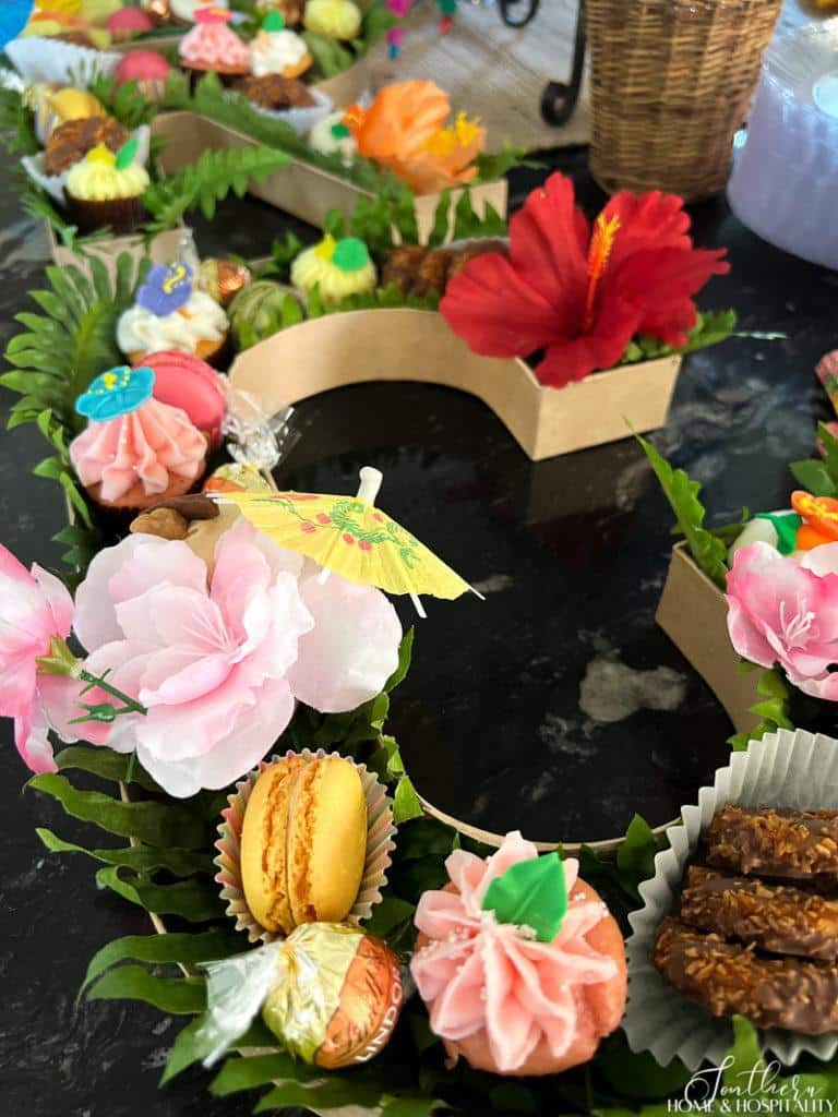 cupcakes, macarons, cookies, and flowers in a letter