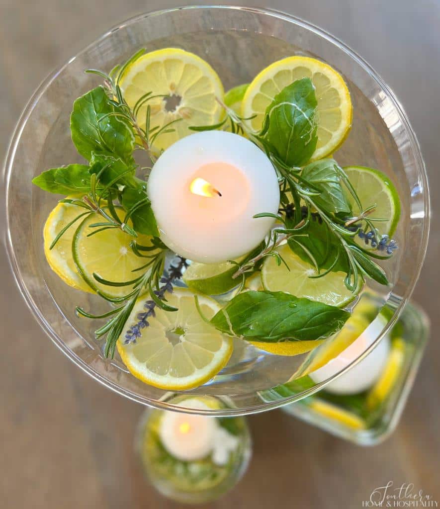 Rosemary, basil, lavender, lemons, and limes in water with a floating candle as a bug deterrent