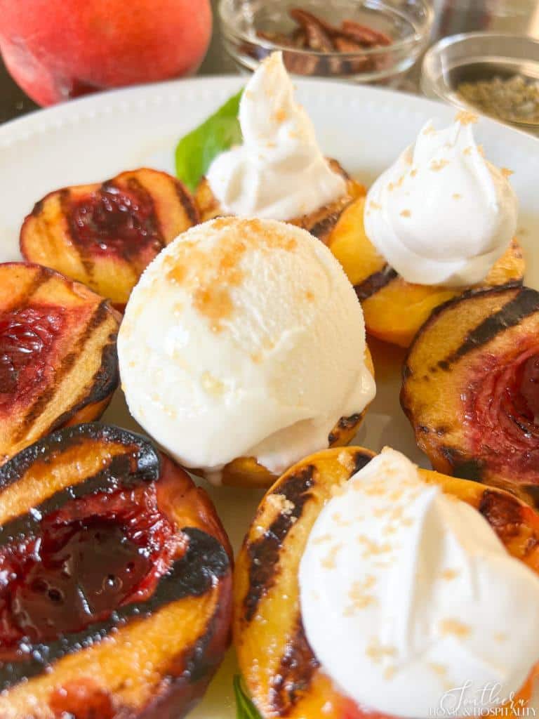 grilled peach topped with ice cream and cream