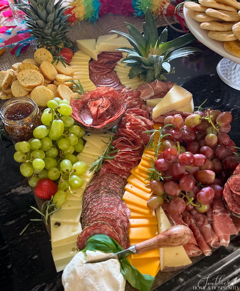 Charcuterie board with rosemary and basil garnish