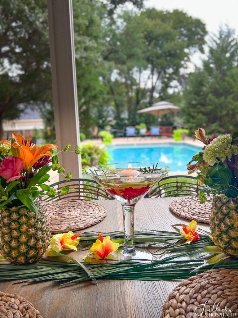 mosquito repelling lemons and herbs in a glass vase with floating candle