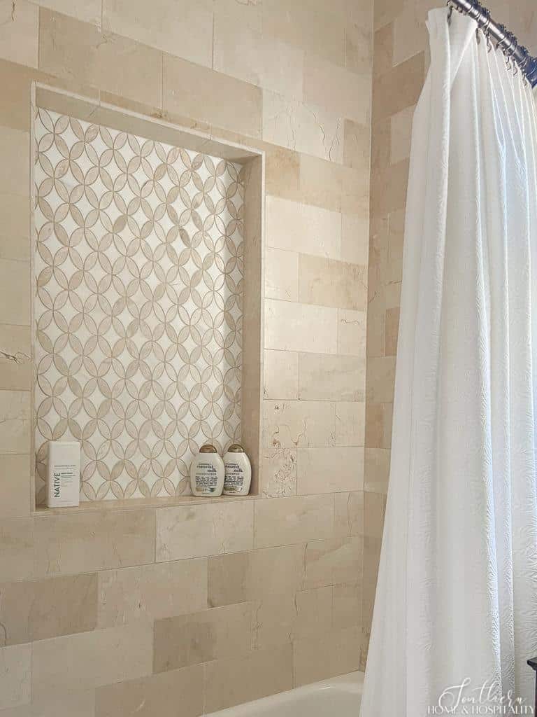 tan and white marble mosaic tile in a shower niche