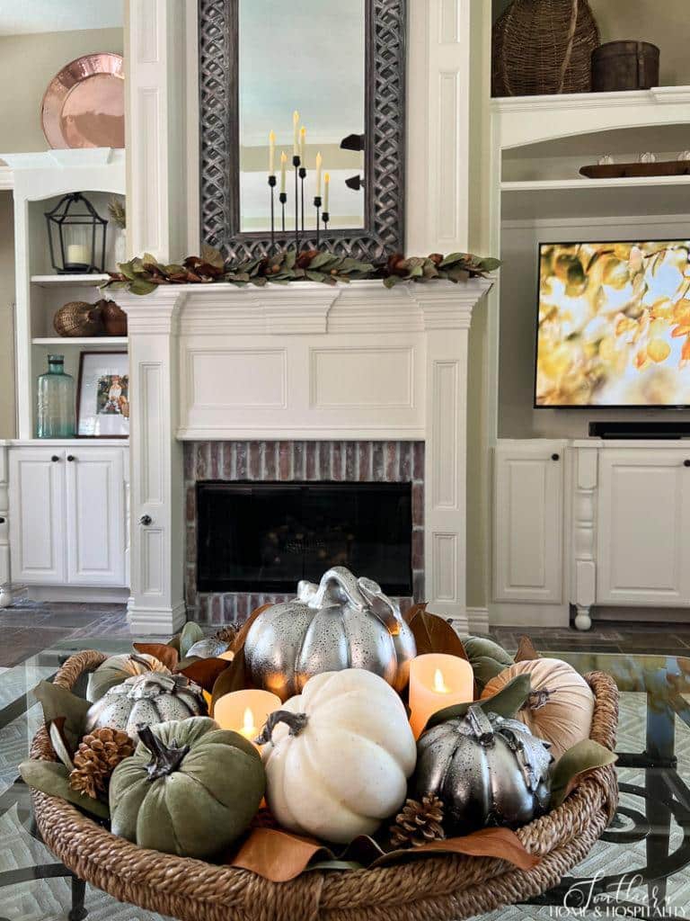 fall coffee table arrangment with pumpkins magnolia leaves and candles