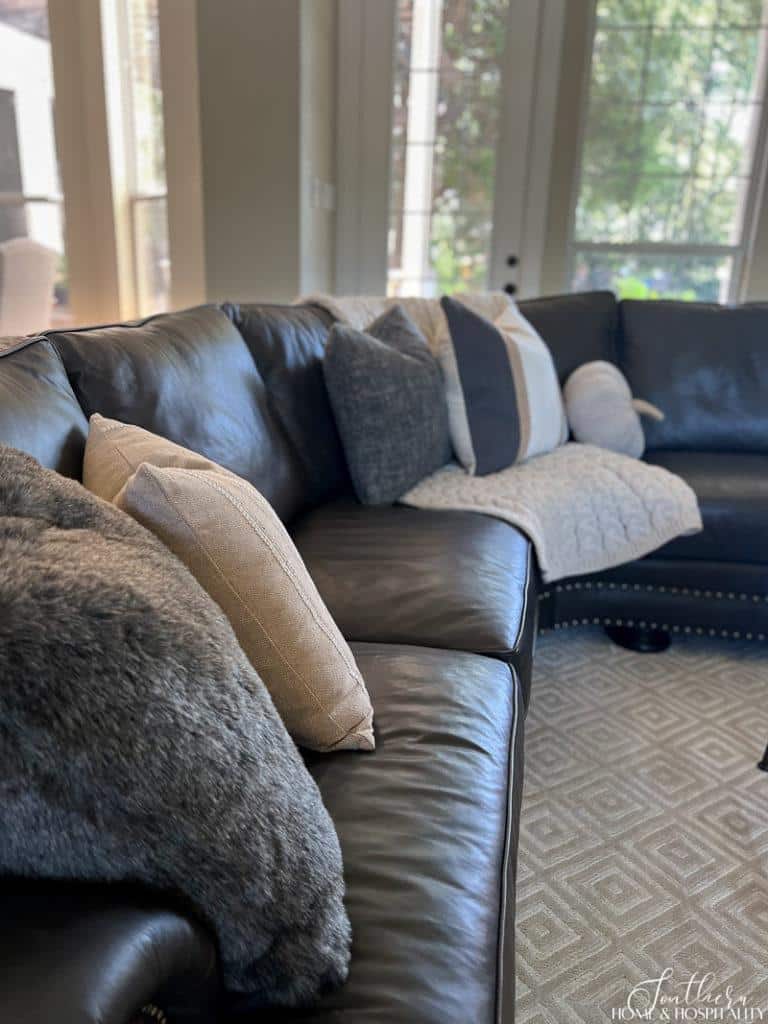 neutral tan and gray throw pillows on leather sofa