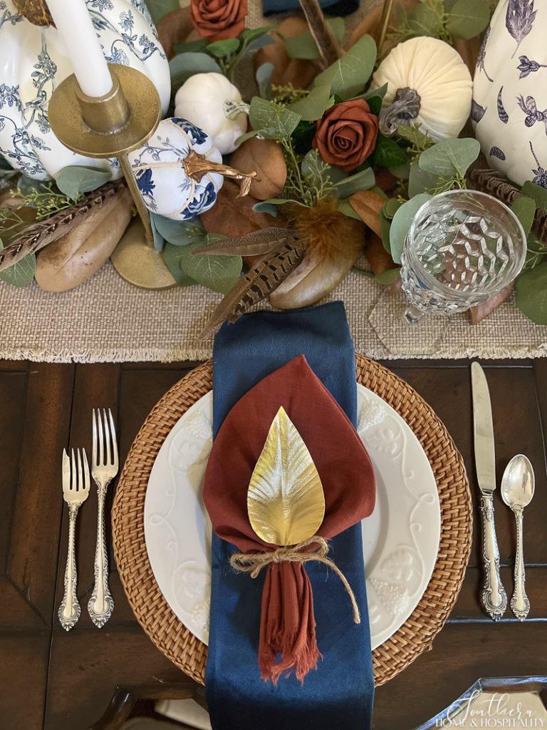 fall table setting with velvet midnight blue napkin and rust napkin with golf leaf