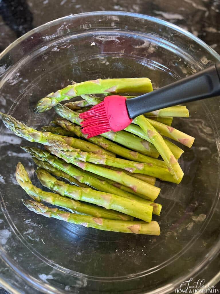 Tossing asparagus spears in olive oil