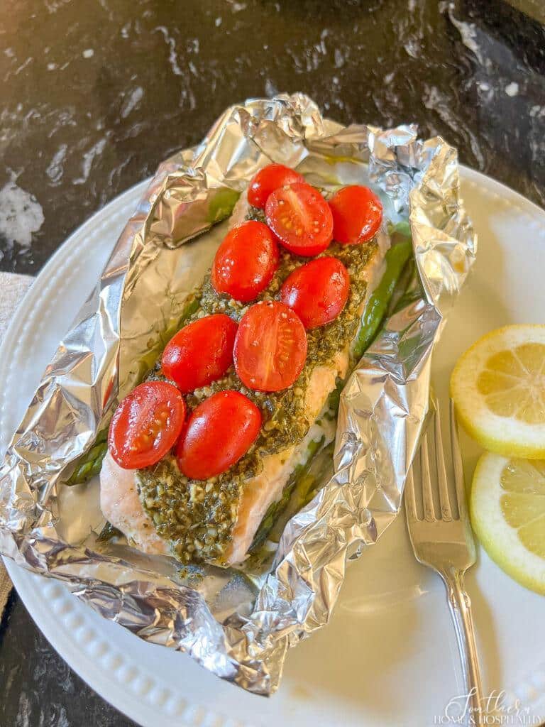 Salmon with basil pesto, tomatoes, and asparagus in foil packet