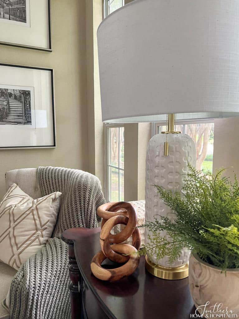 Modern lamp, wood links, and fern on end table