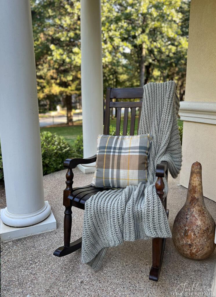 Throw blanket and fall plaid pillow on porch rocker
