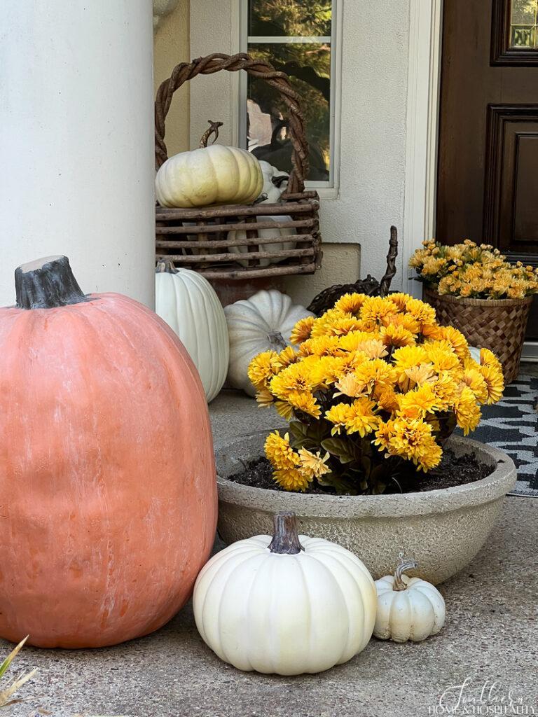 Yellow mums and pumpkins on front porch