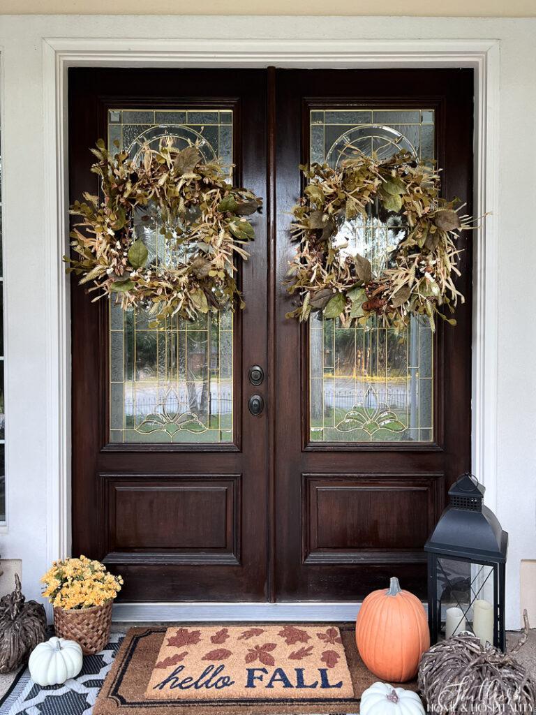 Front doors with fall wreaths and fall doormat