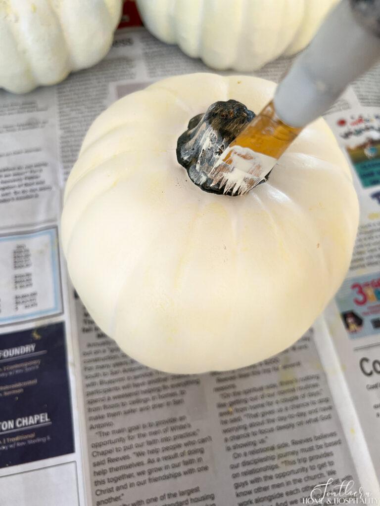 Applying white wax to fake pumpkin stem