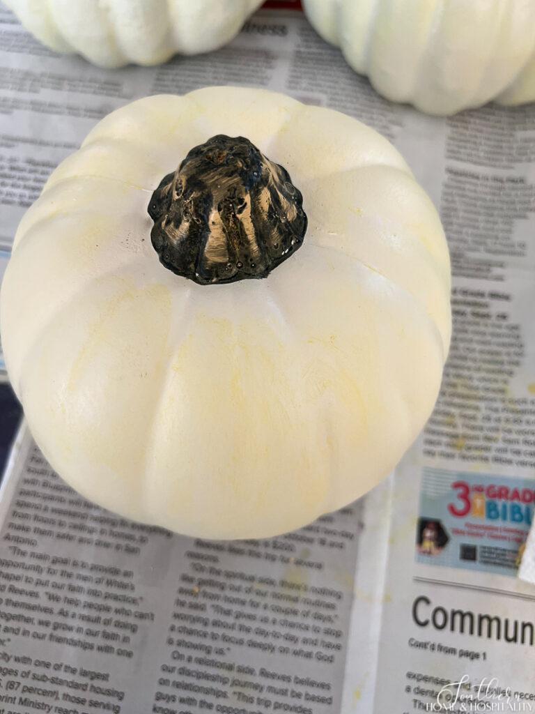 White faux pumpkin with yellow wax