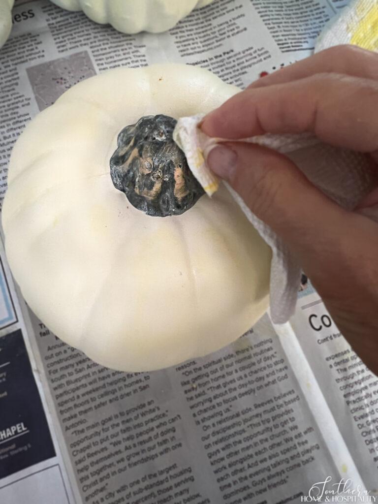 Wiping off white wax from pumpkin stem