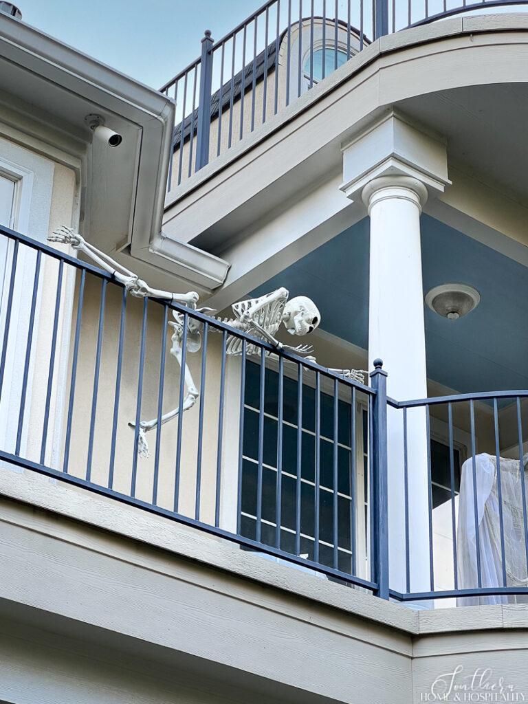 Skeleton climbing over balcony