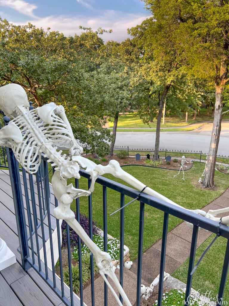 Skeleton attached to balcony railing with zip ties