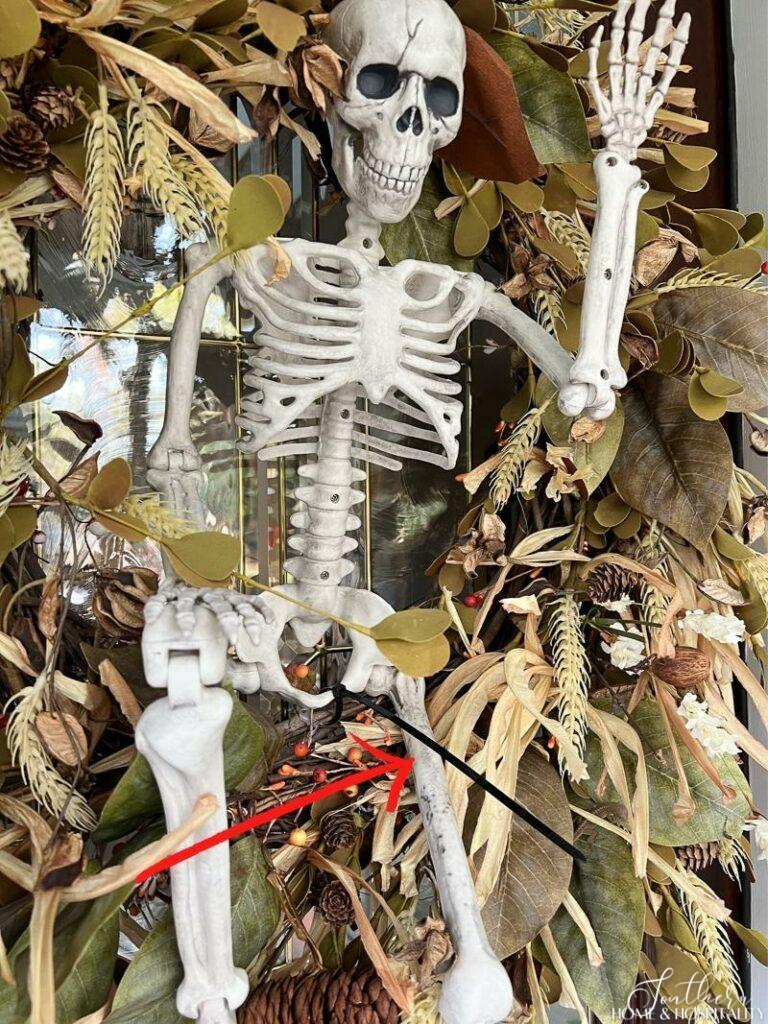 Halloween skeleton attached to wreath with zip tie