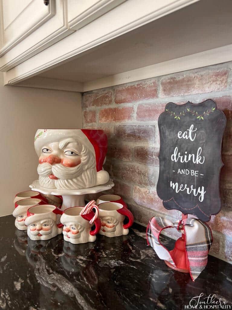 Santa mugs and chalkboard sign on kitchen counter