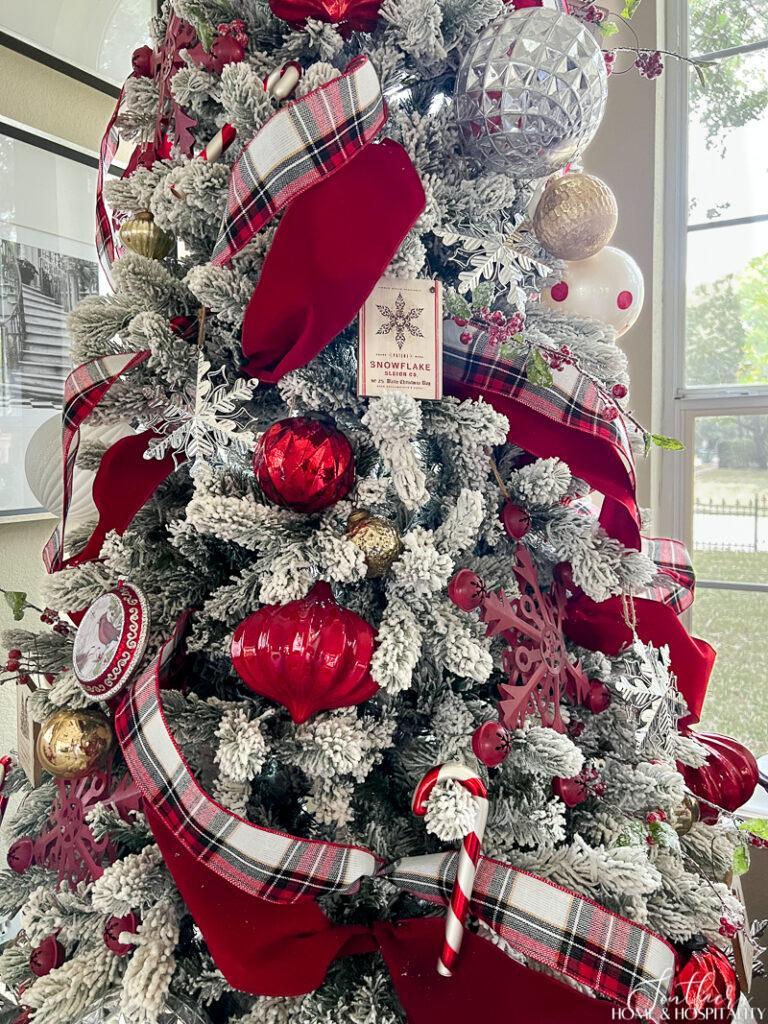 Flocked tree with red and plaid ribbon and red ornaments