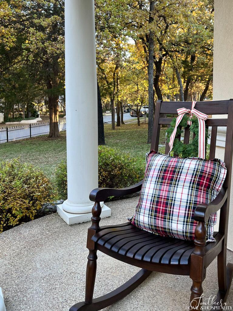 Plaid pillow and Christmas wreath on porch rocker