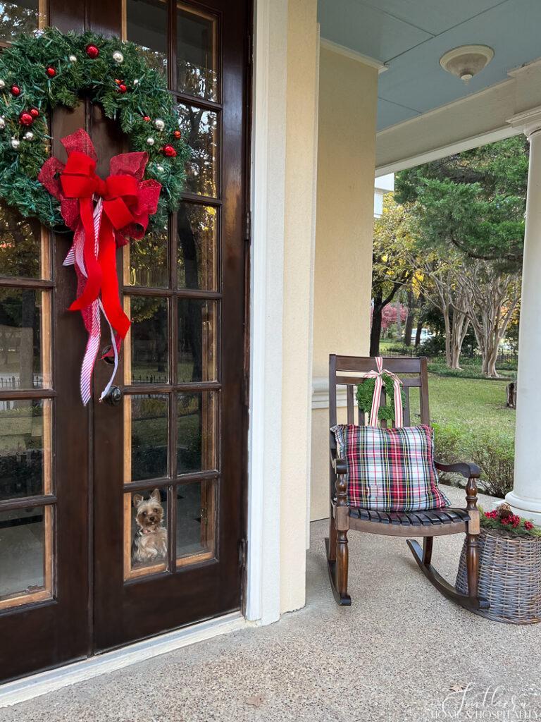 Christmas wreath on French door, porch rocker with plaid pillow and wreath