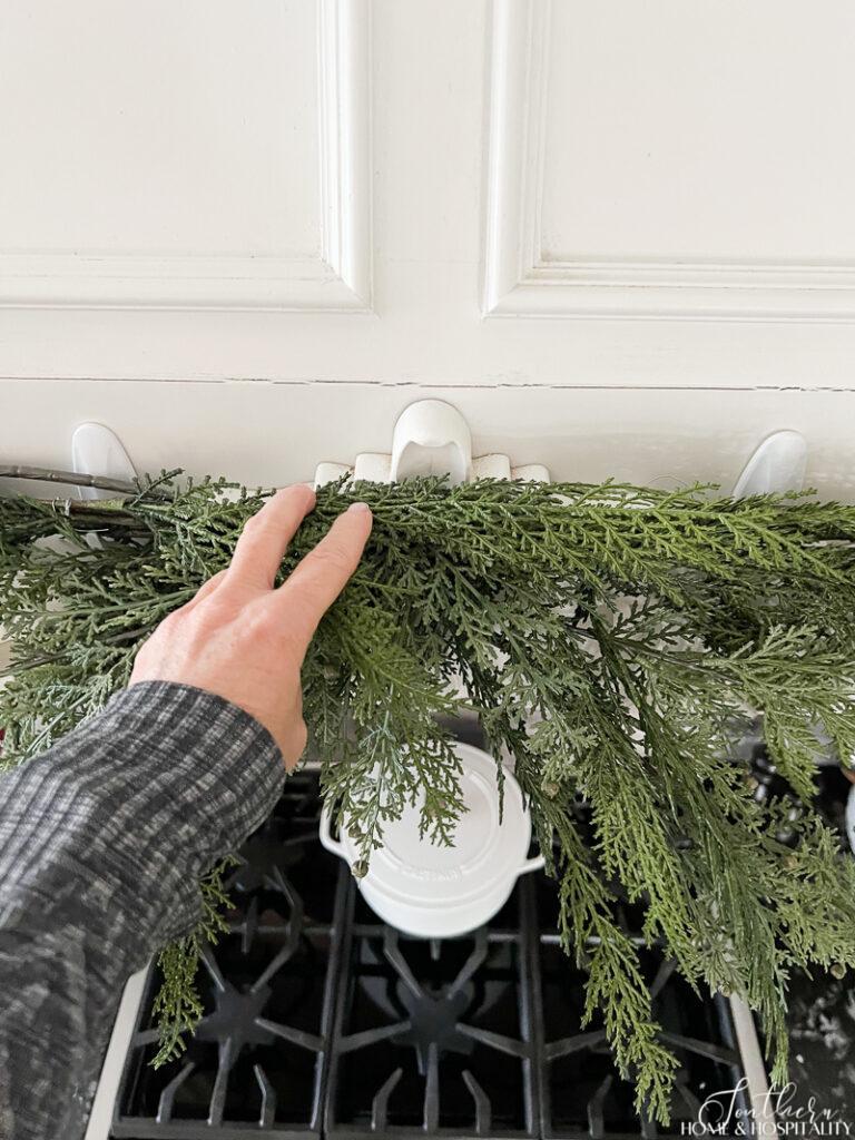 Christmas greenery hung with Command hooks on vent hood