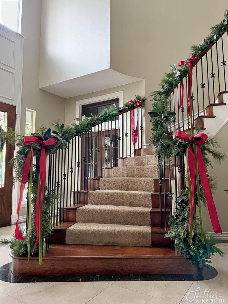 Garland and red and green bows on curved staircase