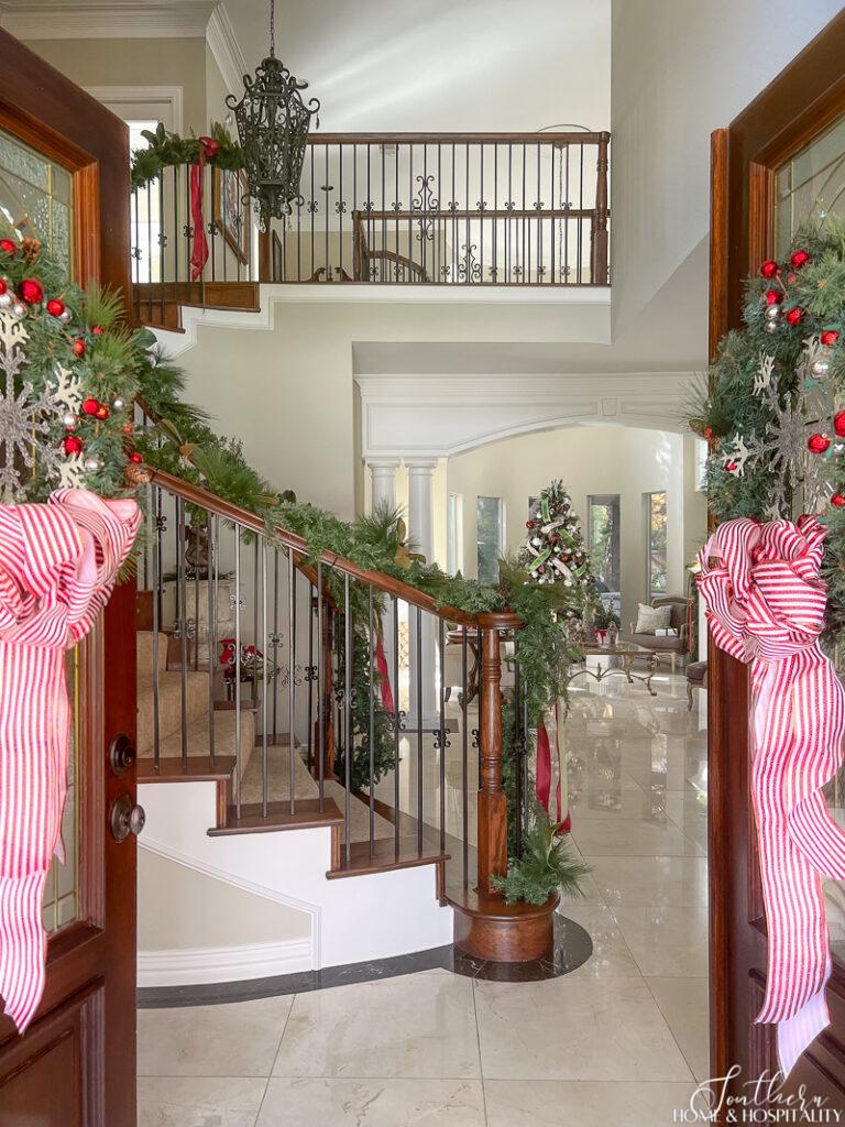 Entry of home with staircase decorated with garland for Christmas