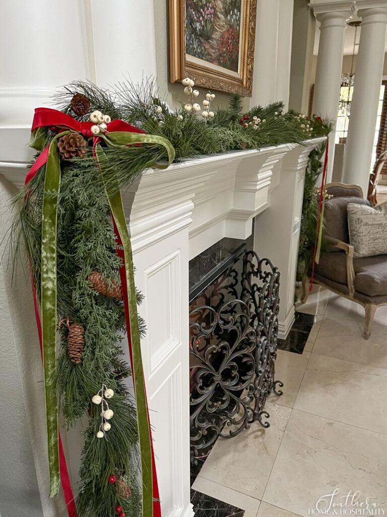 Red, green, and white garland on fireplace mantel