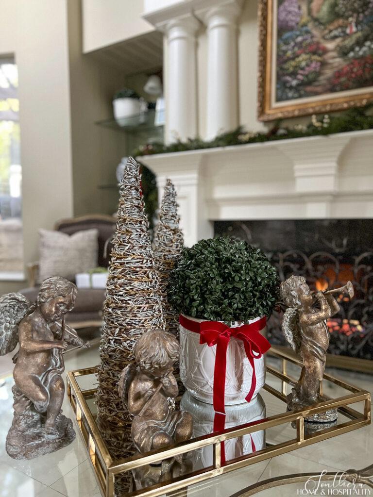 Christmas coffee table decor with angels and boxwood topiary with red velvet ribbon