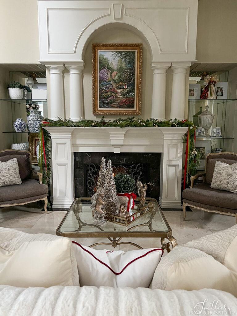Living room mantel with Christmas garland, red and green velvet ribbon