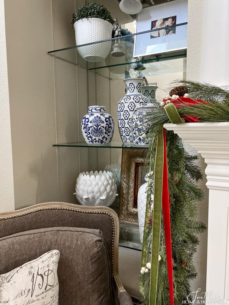 Red and green Christmas garland and blue and white shelf decor