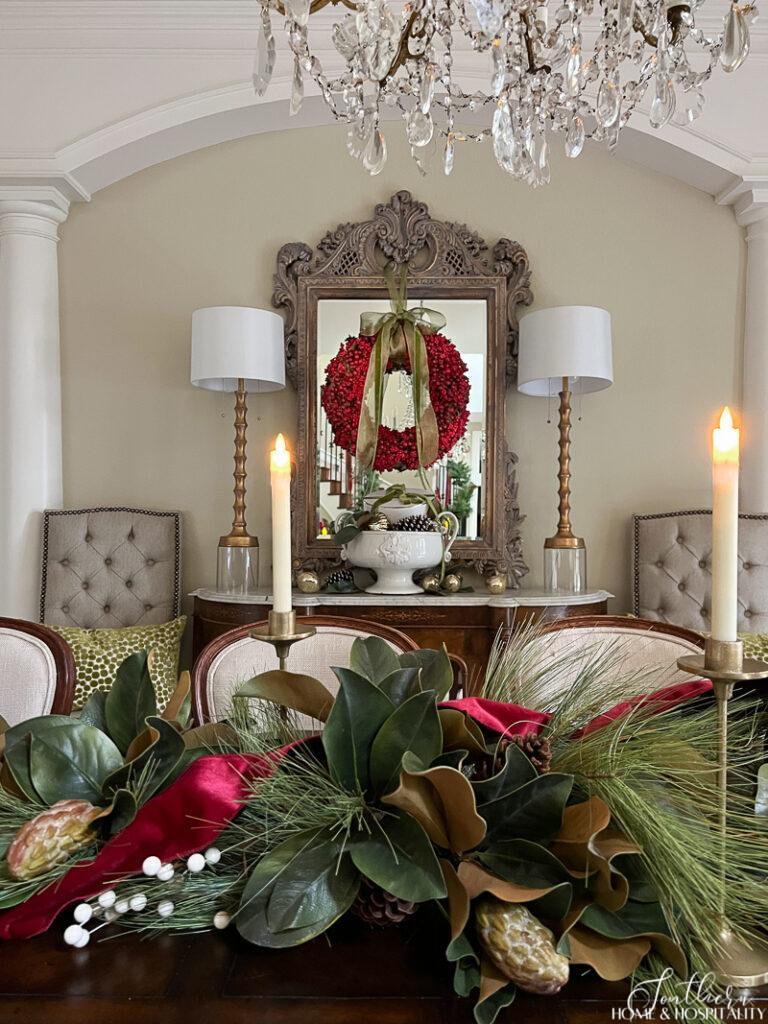 Magnolia and pine centerpiece and Christmas berry wreath on sideboard mirror
