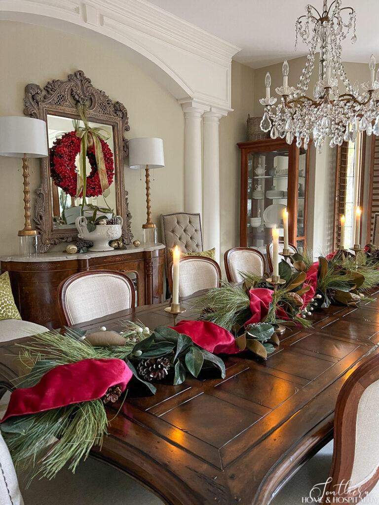Magnolia and pine garland with red velvet ribbon on dining table