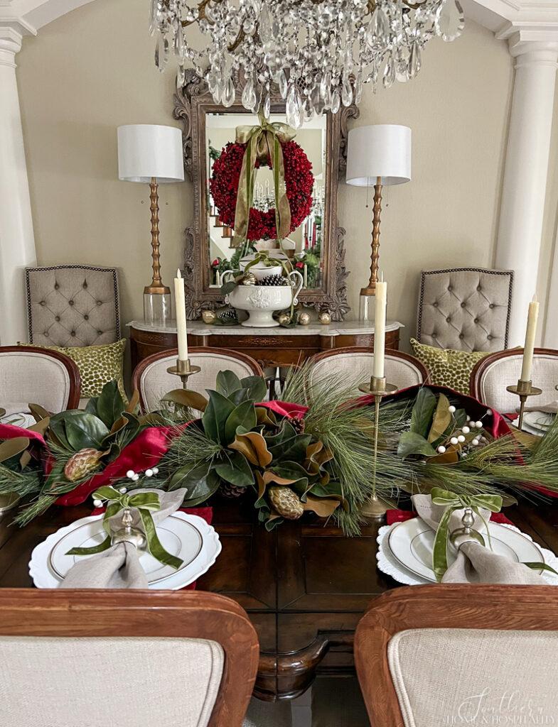 Red and green Christmas tablescape with magnolia and pine garland table centerpiece