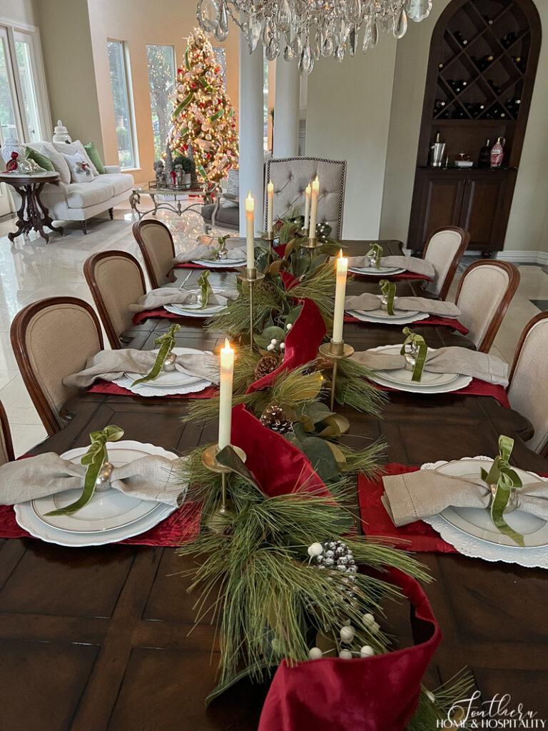 Red and green Christmas tablescape with garland centerpiece