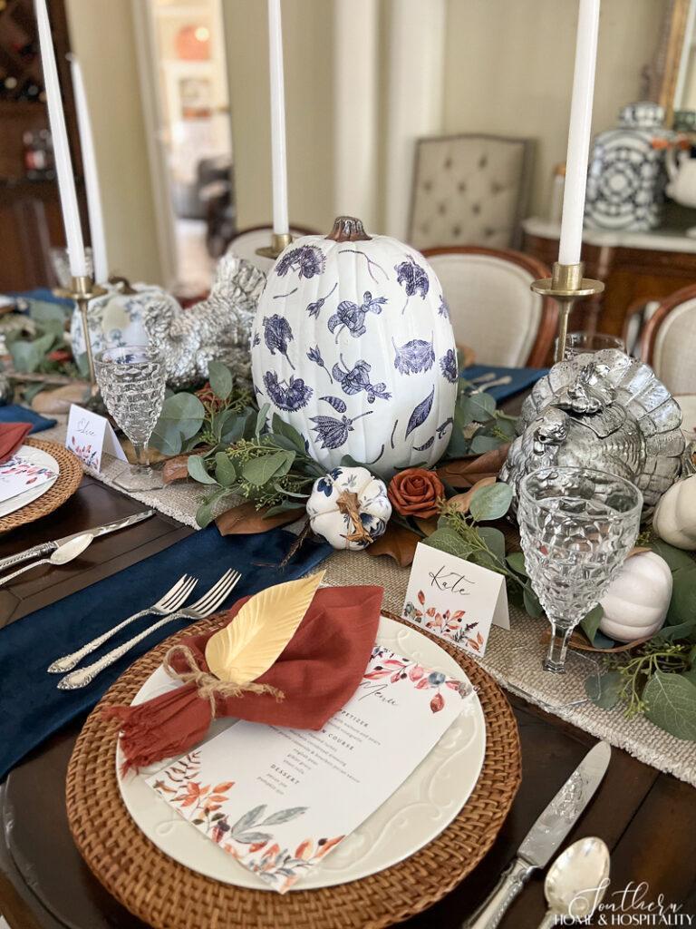 Thanksgiving place setting with blue and rust napkins and printable place cards and menu