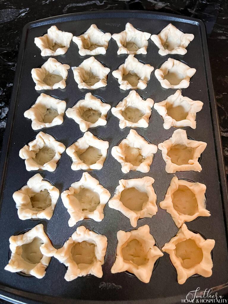 Unbaked empty mini pie shells in a star shape
