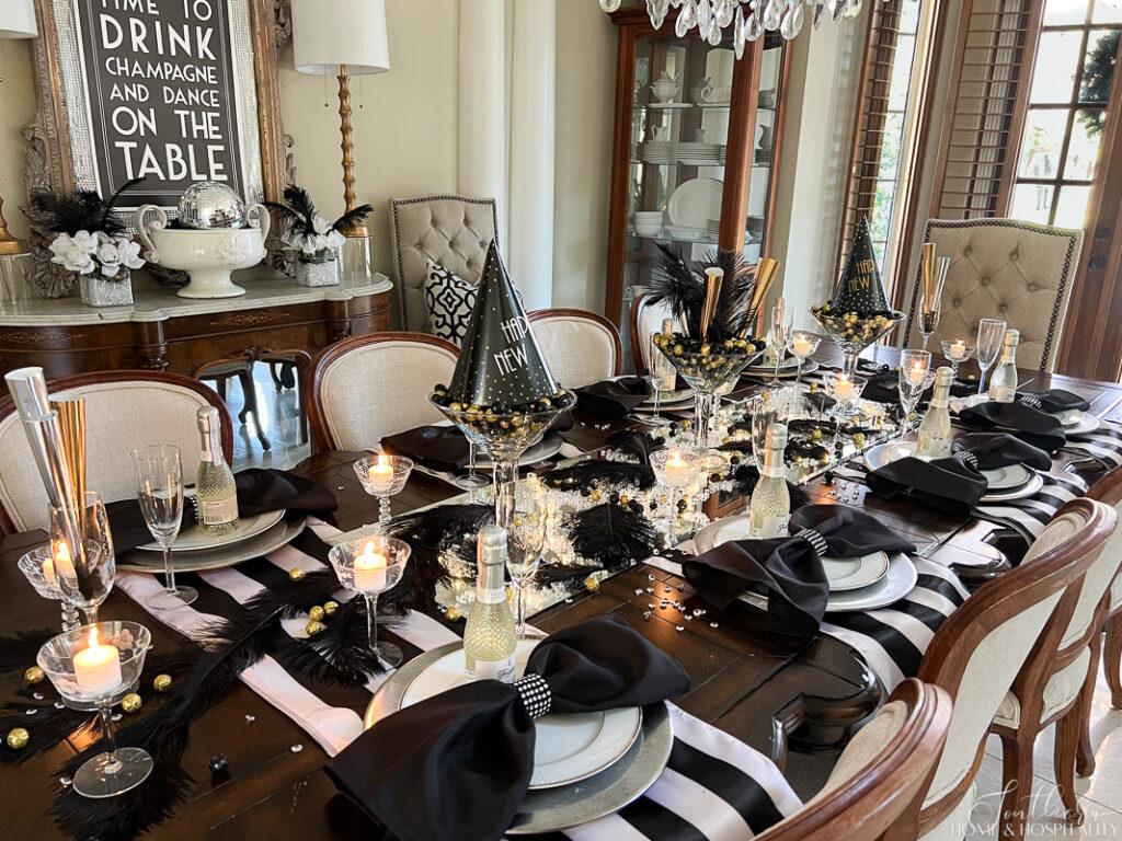 New Year's Eve tablescape with black and white stripe table runners and bow napkins