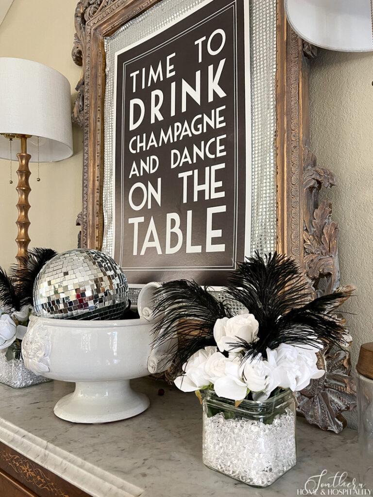 White roses, black feathers, and diamond scatter in a vase