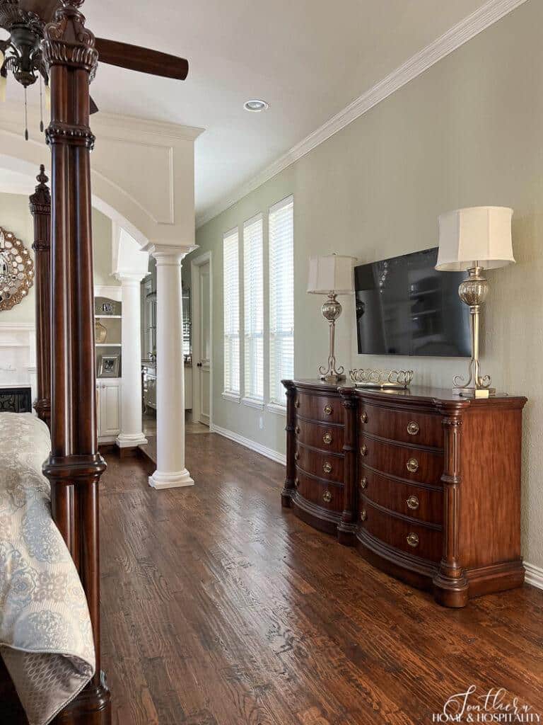 Primary bedroom traditional wood dresser with gold hardware on wood floors