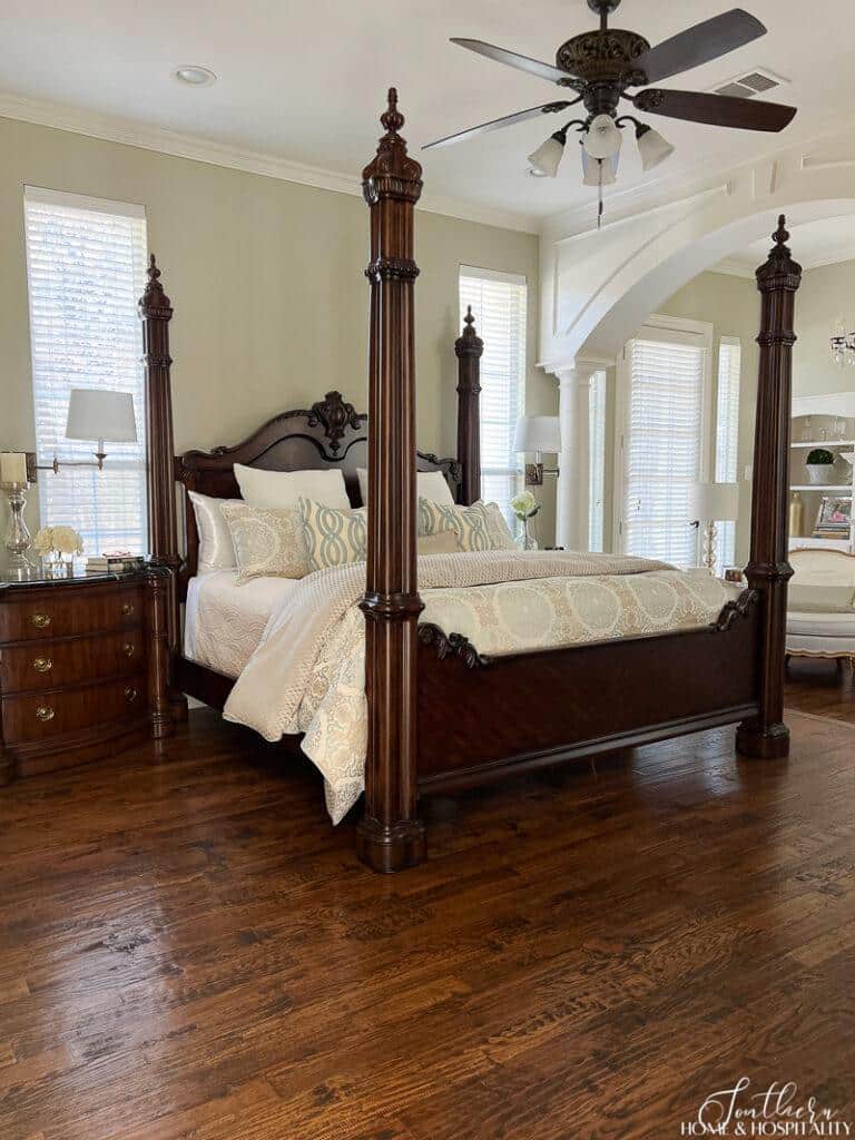 Four poster wood bed with spa blue bedding and green walls